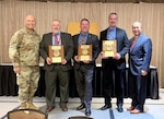 five people stand together with certificates