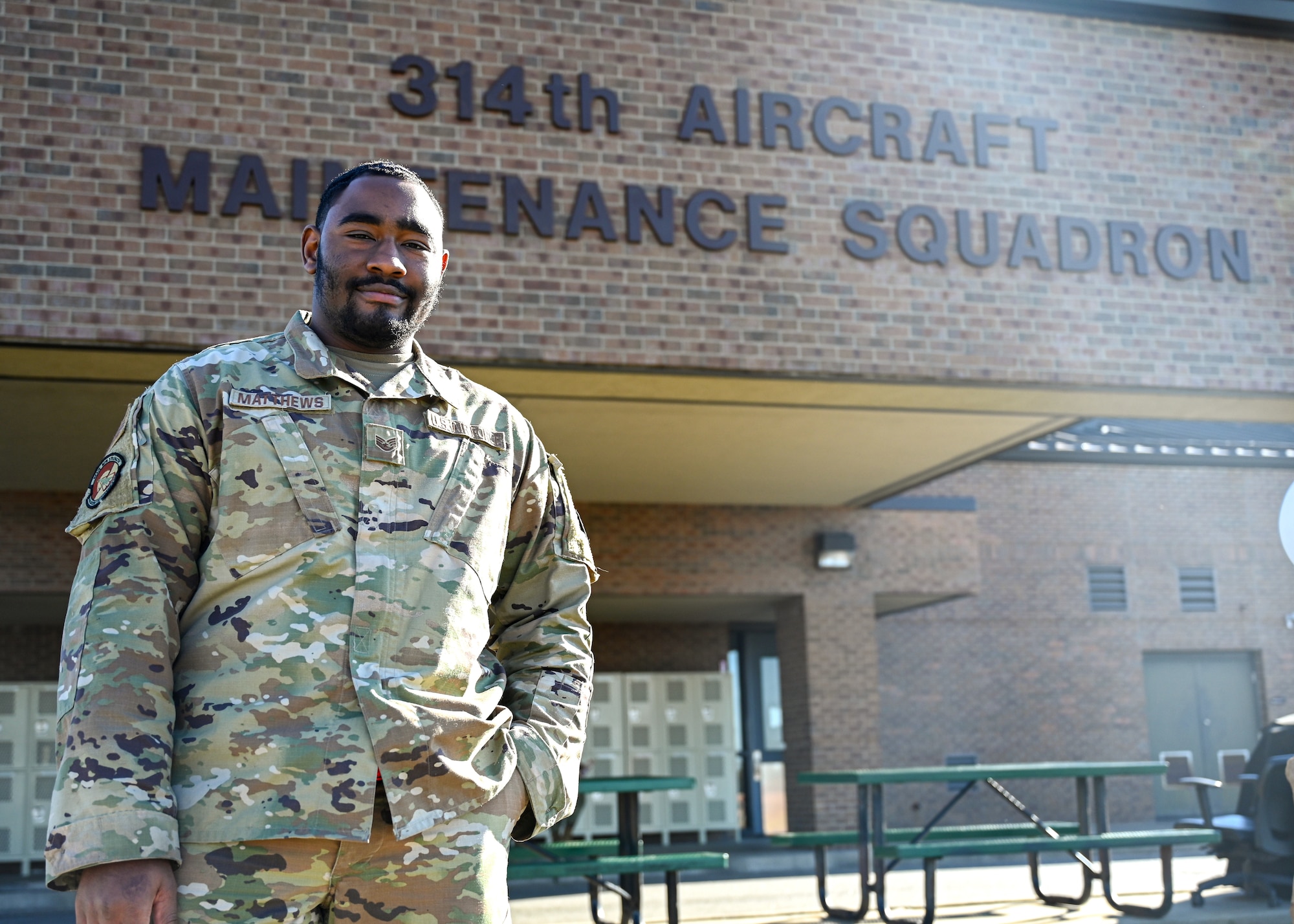 An Airman stands in front of a building.
