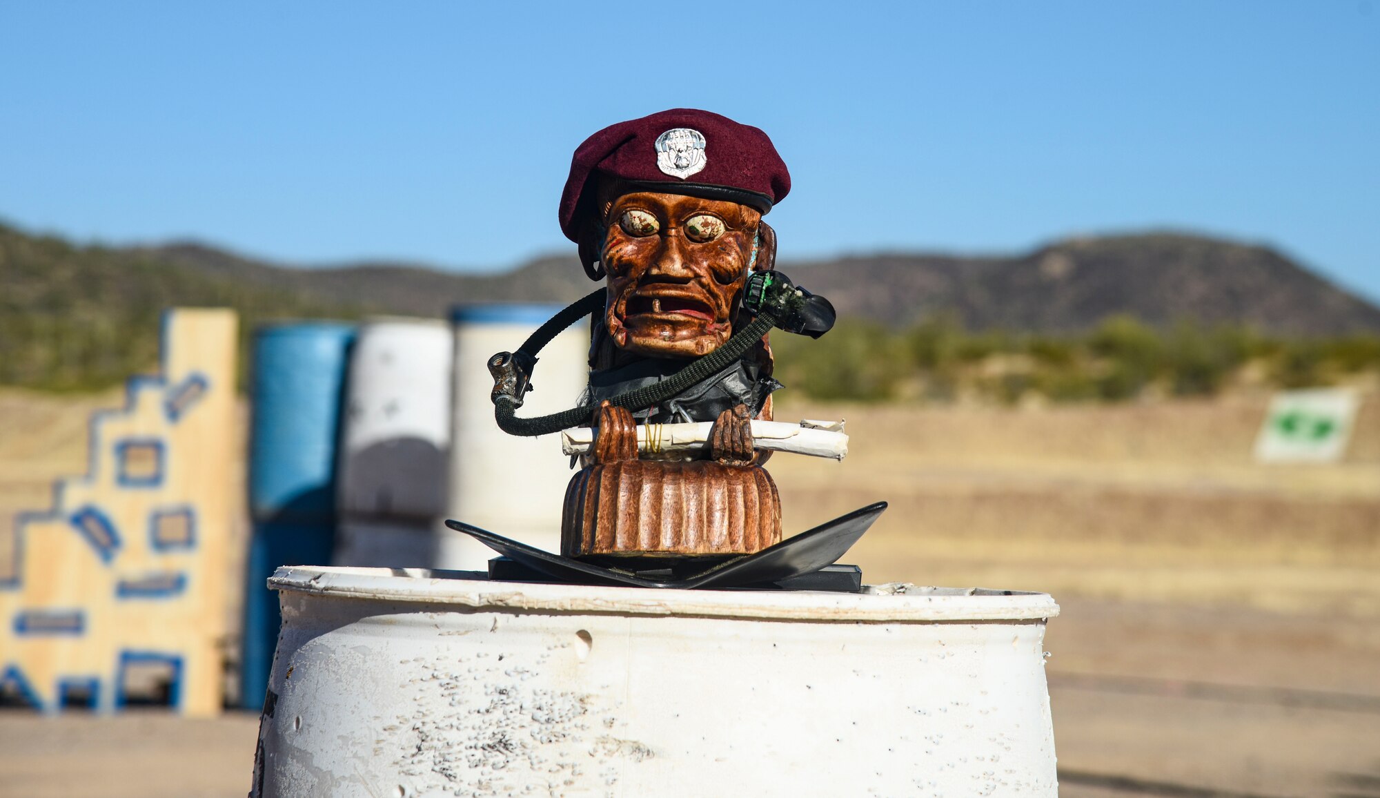 Pictured above is a wooden totem sitting on a plastic barrel.