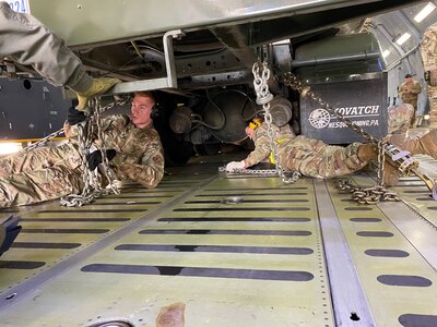 Reserve Citizen Airmen with the 26th and 74th Aerial Port Squadrons secure a fuel delivery truck to the floor of a C-5M Super Galaxy cargo aircraft during a training event Nov. 7, 2021 at Joint Base San Antonio-Lackland, Texas. Properly securing cargo inside the aircraft prevents movement during flight. (Courtesy photo by Tech. Sgt. John Shue)