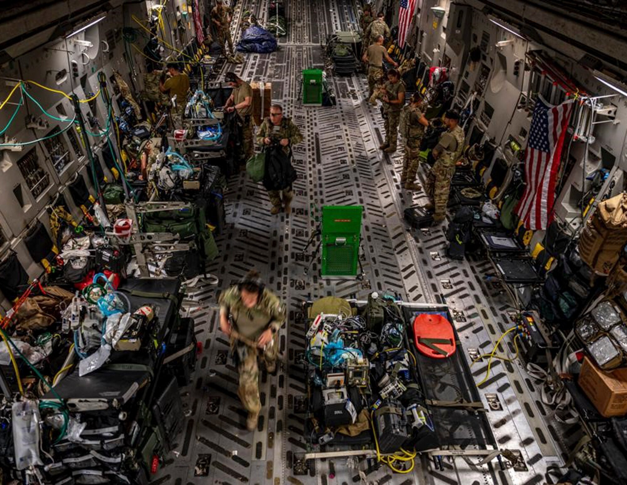 U.S. Air Force Airmen from the 379th Expeditionary Aeromedical Evacuation Squadron prepare their equipment on a C-17 Globemaster III over the skies of U.S. Central Command, Aug. 26, 2021.