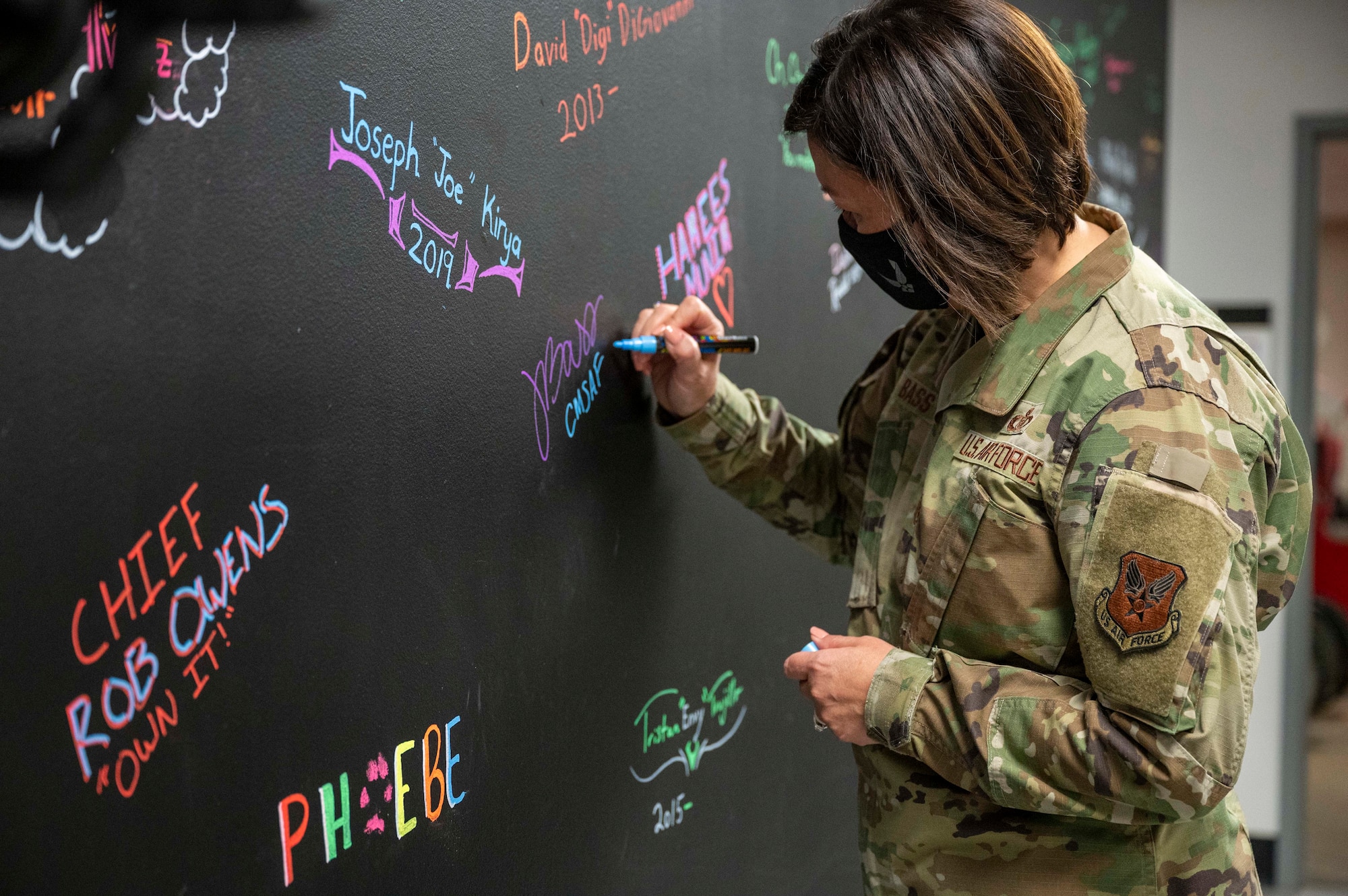 A person signs a wall