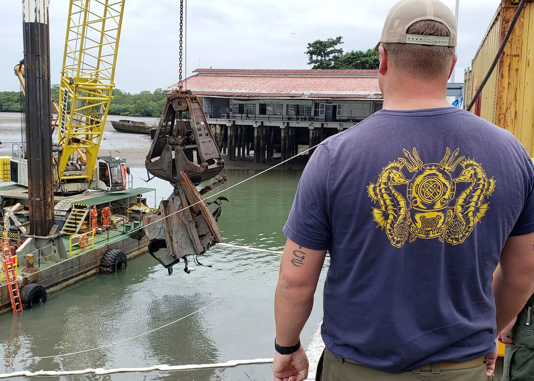 Senior Chief Navy Diver Sean McConnell, a master diver assigned to Mobile Diving and Salvage Unit (MDSU) 2, watches as wreckage separated from a sunken vessel is hauled up and moved into wet storage.