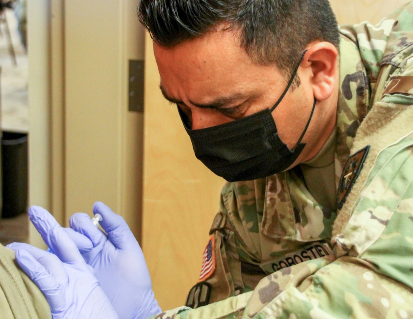 Kentucky Army National Guard Sgt. Roberto Gorostieta, a combat medic with the 130th Engineer Support Company and vaccination team non-commissioned officer, administers COVID-19 vaccination at the Boone National Guard Center, in Frankfort, Ky., November 6, 2021