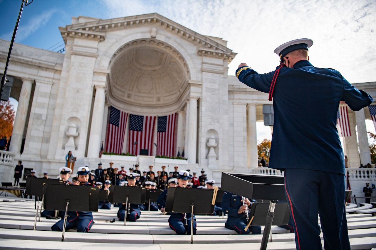 A service member directs a band.