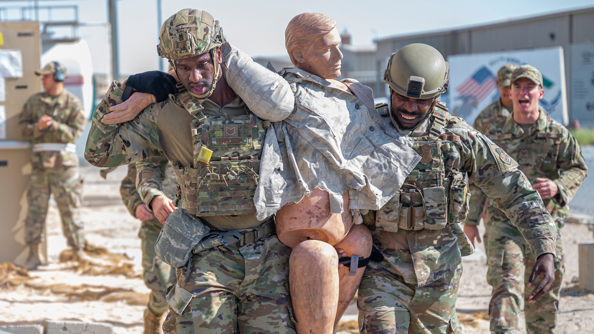 Tech. Sgts. Omari Ferguson and Brandon Kelly, both assigned to the 386th Expeditionary Security Forces Squadron, carry a training dummy during Tactical Combat Casualty Care training at Al Jaber Air Base, Kuwait, Nov. 5, 2021.