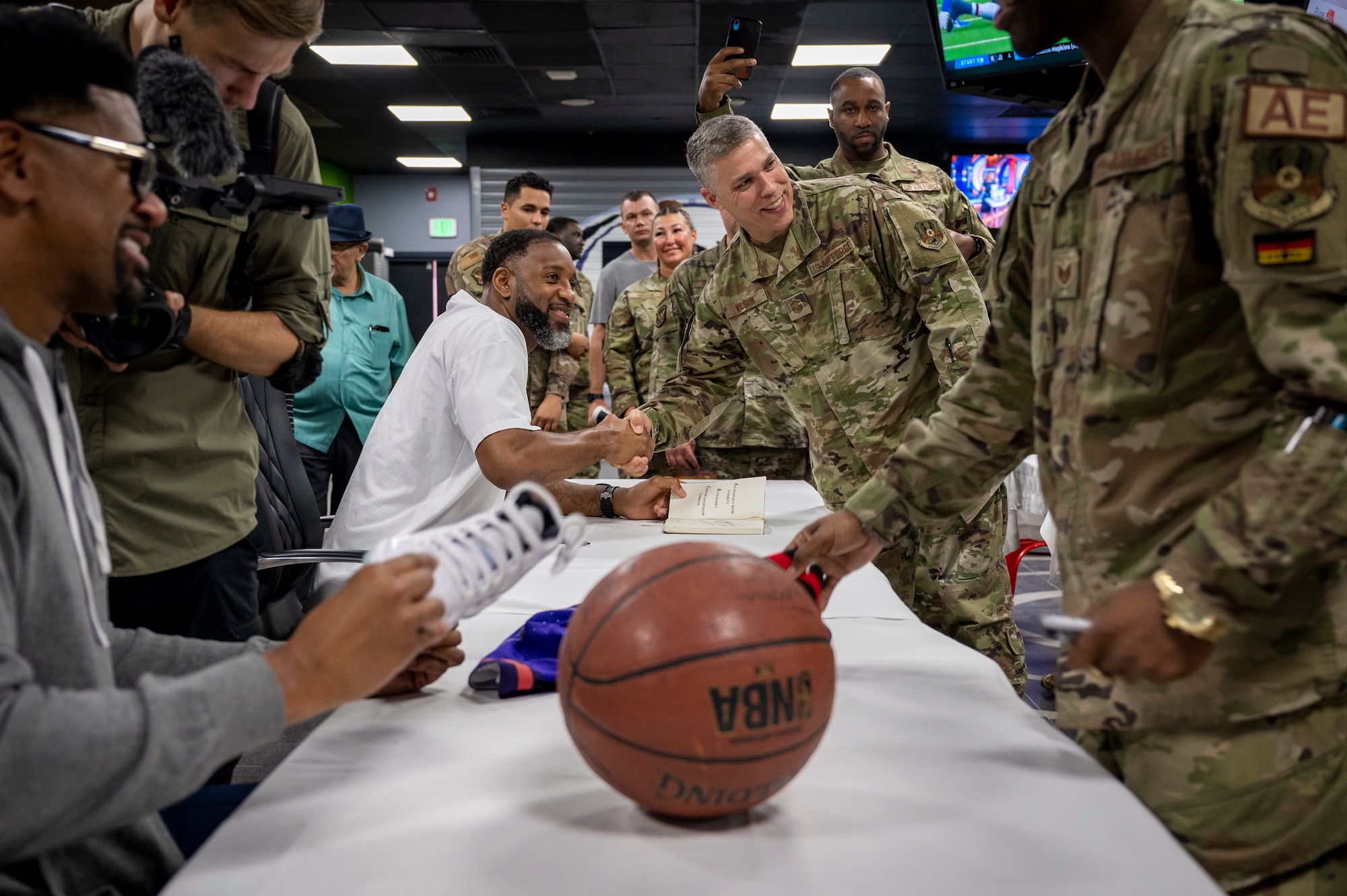 An Airman poses for a photo with Tracy McGrady at a luncheon Nov. 11, 2021 at Al Udeid Air Base, Qatar.