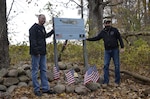 Crowd gathers around a Veterans Day memorial.