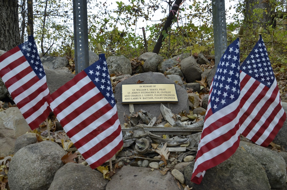 4 small flags fly as part of the memorial honoring the lives of four US Navy personnel.