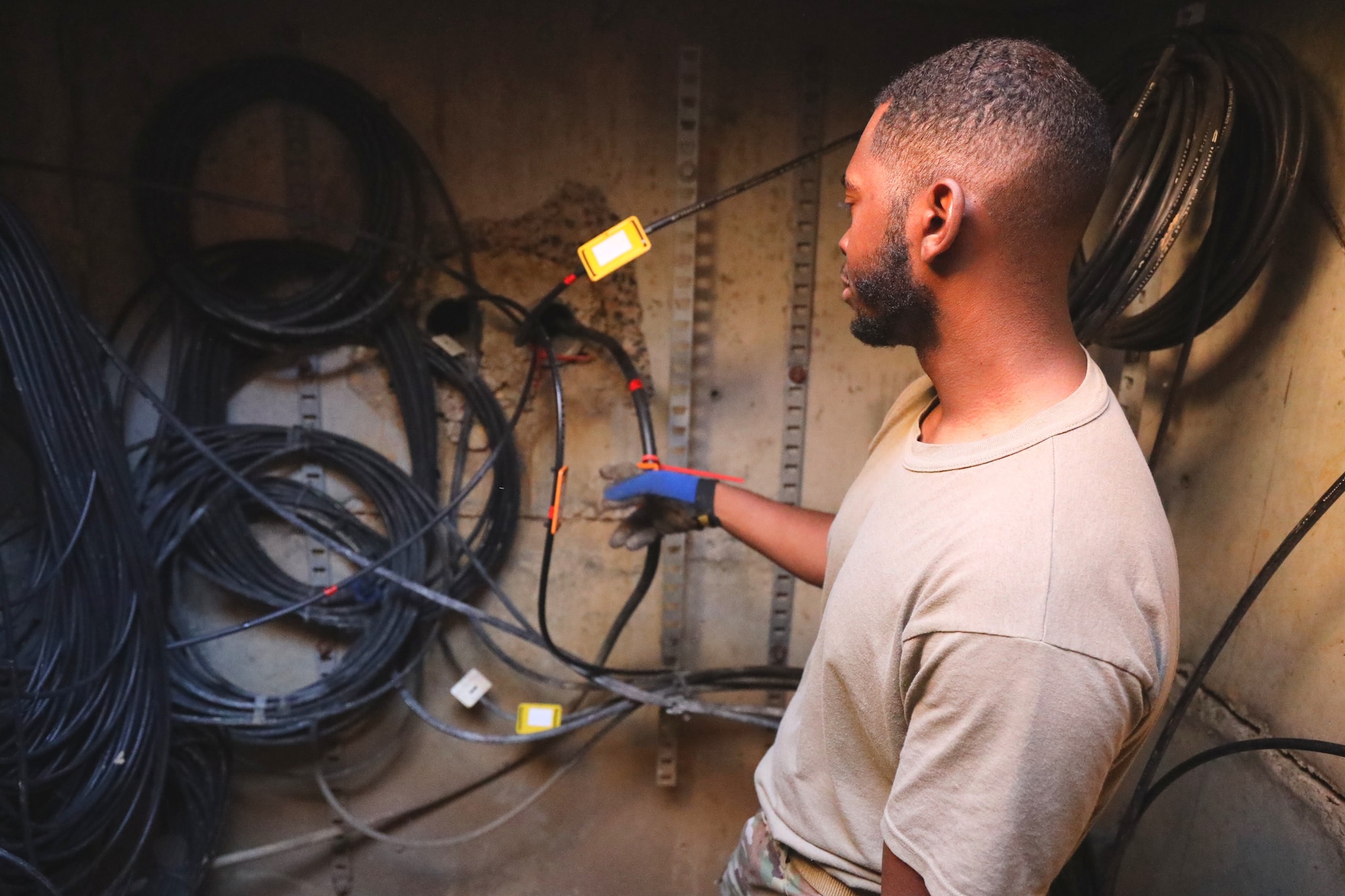 U.S. Air Force Staff Sgt. Andrew Langford, 794th Communications Squadron cable antenna technician, inspects fiber optic cables at Joint Base Anacostia-Bolling, Washington, D.C., Nov. 9, 2021.  Inside the manhole Airmen from the 794th CS cable and antenna systems shop, or cable dawgs, maintain fiber optic cable used to run communication lines throughout the entire base. 
By installing and maintaining fiber optics, copper and coaxial lines, cable and antenna systems specialists, ensure the installation has efficient means of communication required to accomplish mission needs. (U.S. Air Force photo by Airmen 1st Class Anna Smith)