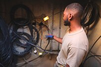 U.S. Air Force Staff Sgt. Andrew Langford, 794th Communications Squadron cable antenna technician, inspects fiber optic cables at Joint Base Anacostia-Bolling, Washington, D.C., Nov. 9, 2021.  Inside the manhole Airmen from the 794th CS cable and antenna systems shop, or cable dawgs, maintain fiber optic cable used to run communication lines throughout the entire base. 
By installing and maintaining fiber optics, copper and coaxial lines, cable and antenna systems specialists, ensure the installation has efficient means of communication required to accomplish mission needs. (U.S. Air Force photo by Airmen 1st Class Anna Smith)