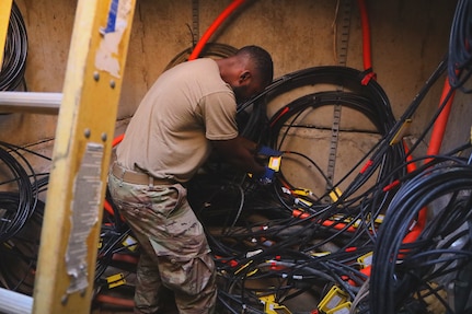 U.S. Air Force Staff Sgt. Andrew Langford, 794th Communications Squadron cable antenna technician, inspects fiber optic cables at Joint Base Anacostia-Bolling, Washington, D.C., Nov. 9, 2021.  Inside the manhole Airmen from the 794th CS cable and antenna systems shop, or cable dawgs, maintain fiber optic cable used to run communication lines throughout the entire base. 
By installing and maintaining fiber optics, copper and coaxial lines, cable and antenna systems specialists, ensure the installation has efficient means of communication required to accomplish mission needs. (U.S. Air Force photo by Airmen 1st Class Anna Smith)