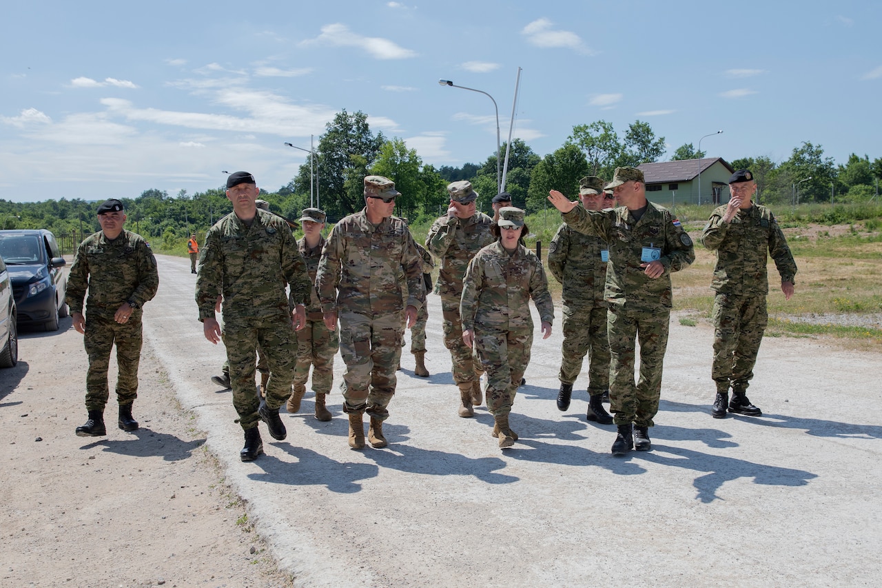 A group of service members walk down a road.