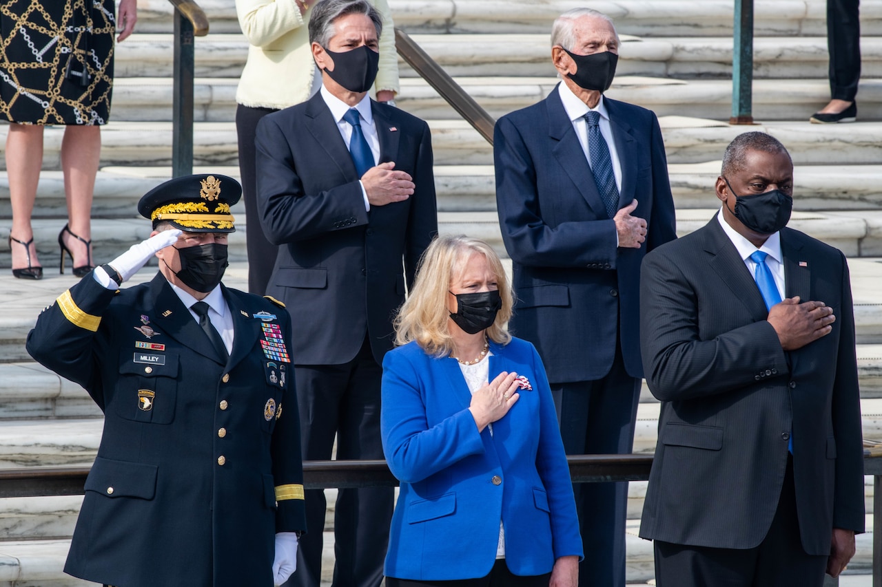DOD officials and guests render honors during Taps at Arlington National Cemetery.