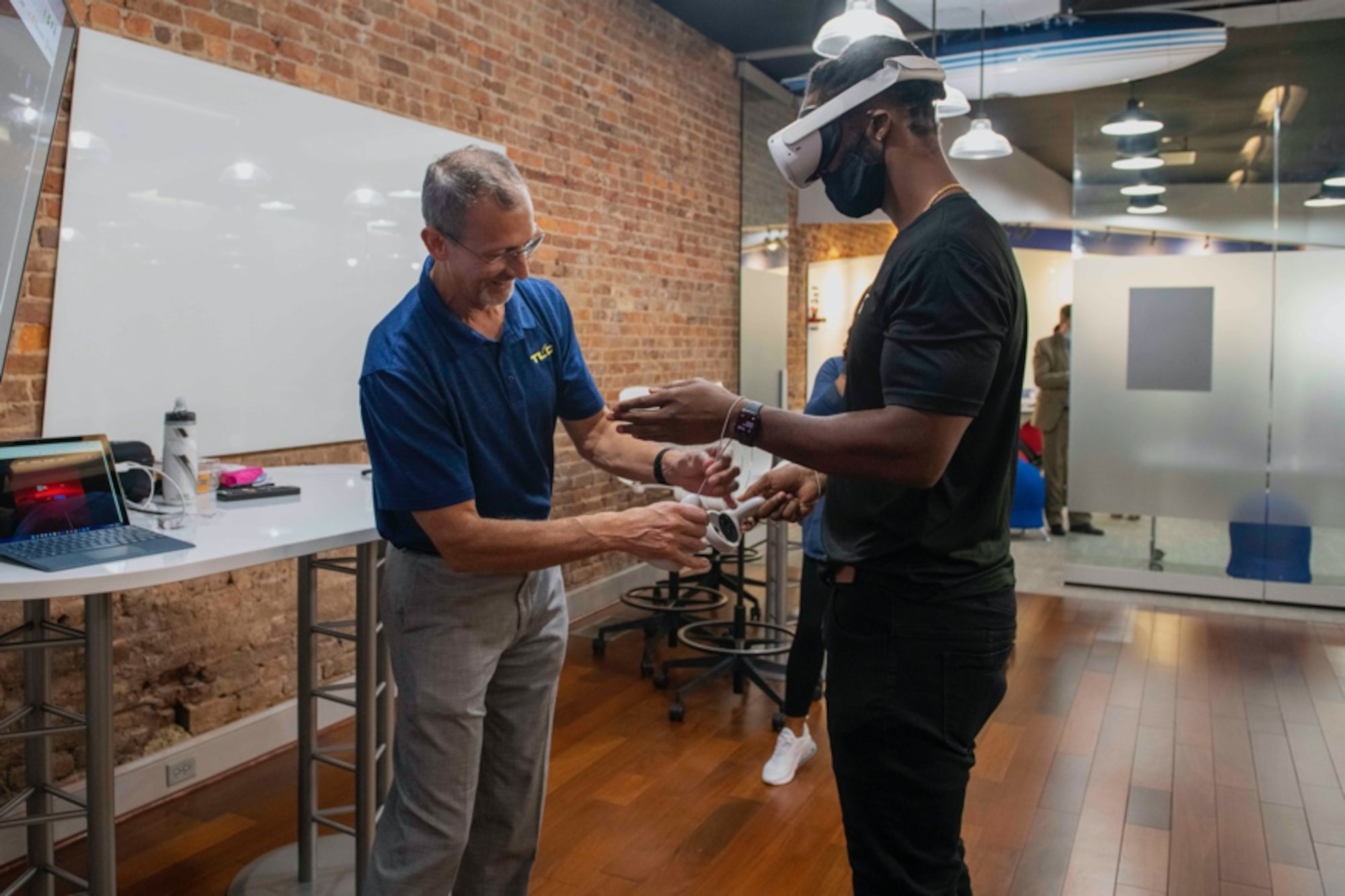 Douglas McCarty, an instructional systems developer from the Air University Teaching and Learning Center, helps an event attendee try out a virtual reality headset during the MGMWERX AR/VR iExpo in Montgomery, Alabama, Nov. 9, 2021. MGMWERX works alongside Air University to promote innovation and collaboration in unique ways through experimentation with emerging tools, processes, and methods to get innovation to the warfighter faster. (U.S. Air Force photo by Staff Sgt. Lauren Silverthorne)