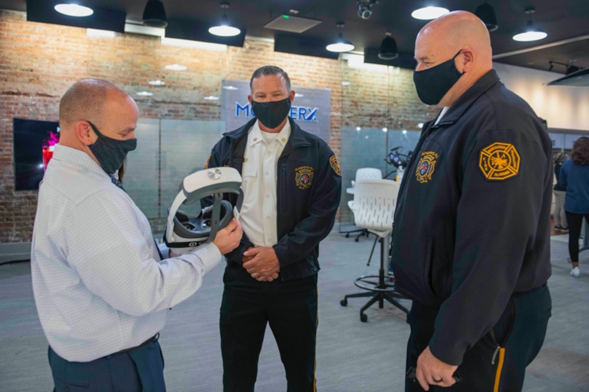 Dr. Andy Clayton, assistant professor of leadership and augmented reality/virtual reality research task force director at Air University, discusses the benefits of introducing AR/VR to education and training programs with two local firefighters during the MGMWERX AR/VR iExpo in Montgomery, Alabama, Nov. 9, 2021. Clayton explained that this type of immersive learning can help people retain information from their VR experience and allows them to interact with educational content. (U.S. Air Force photo by Staff Sgt. Lauren Silverthorne)
