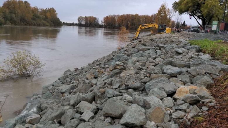 Photo of solo dump truck used to stabilize a damaged levee Nov. 12, 2021, by placing rock armor along a 150 linear feet section on the left bank of the Skagit River, Washington, to mitigate against levee failure during the flood.