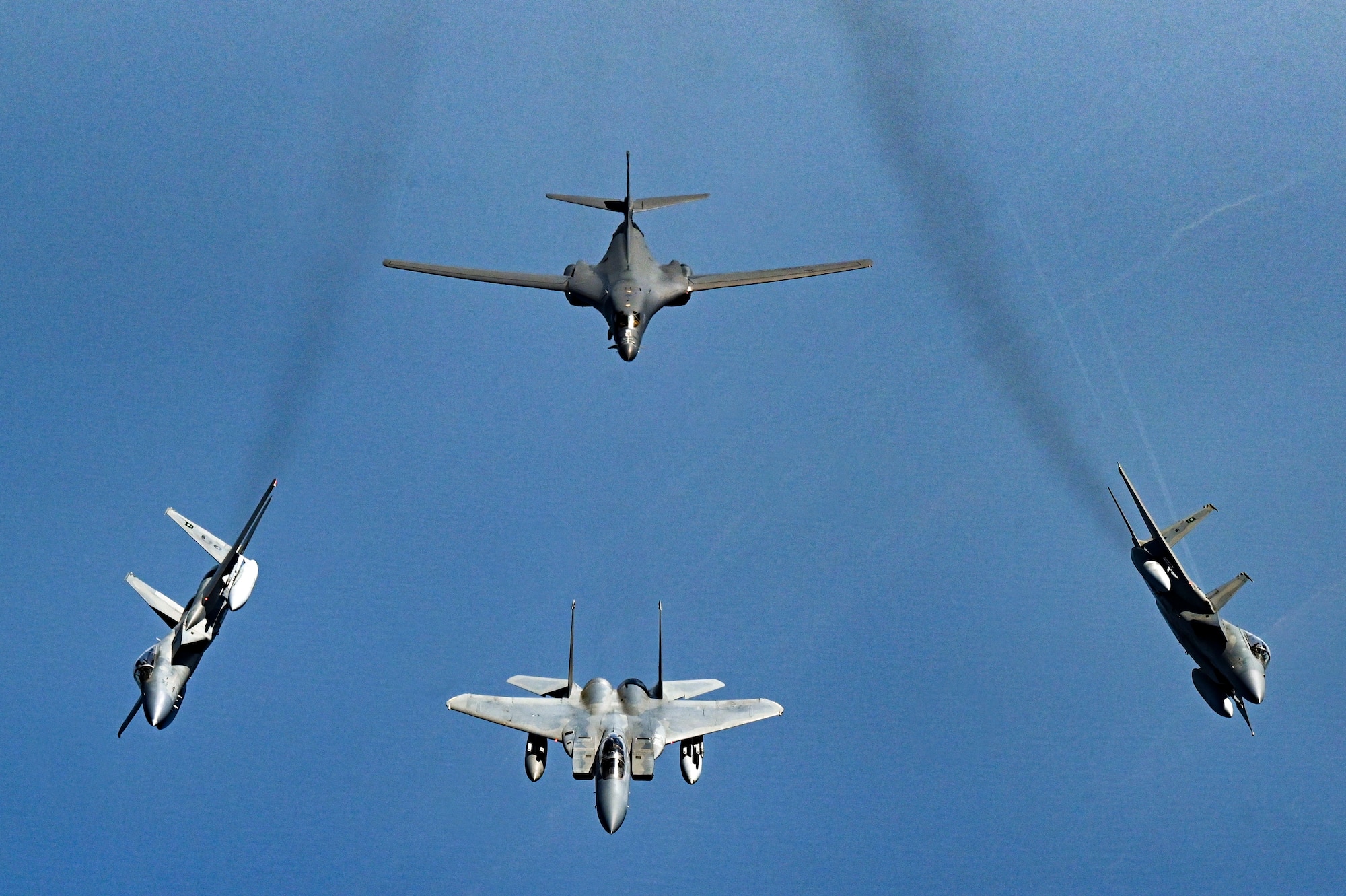 F-15 Strike Eagles break away from a formation with a B-1B Lancer over the Red Sea.