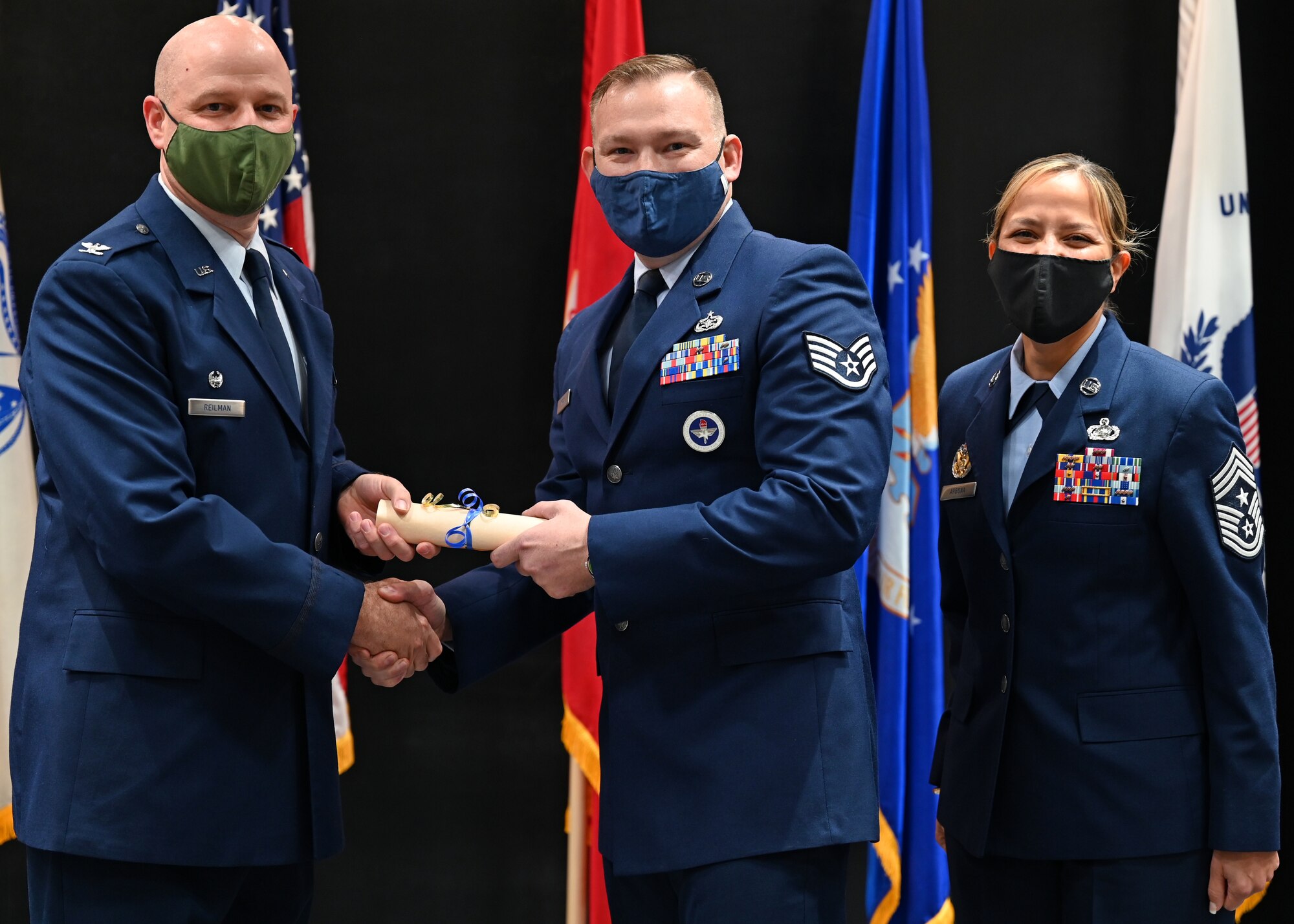 U.S. Air Force Col. Matthew Reilman, 17th Training Wing commander, presents Staff Sgt. Donald Moon, 312th Training Squadron special instruments training instructor, with a diploma from the Community College of the Air Force at the CCAF graduation in the Powell Event Center, Nov. 10, 2021. Moon and other graduates gained their associate of applied science degree through hard work and dedication. (U.S. Air Force photo by Senior Airman Ethan Sherwood)