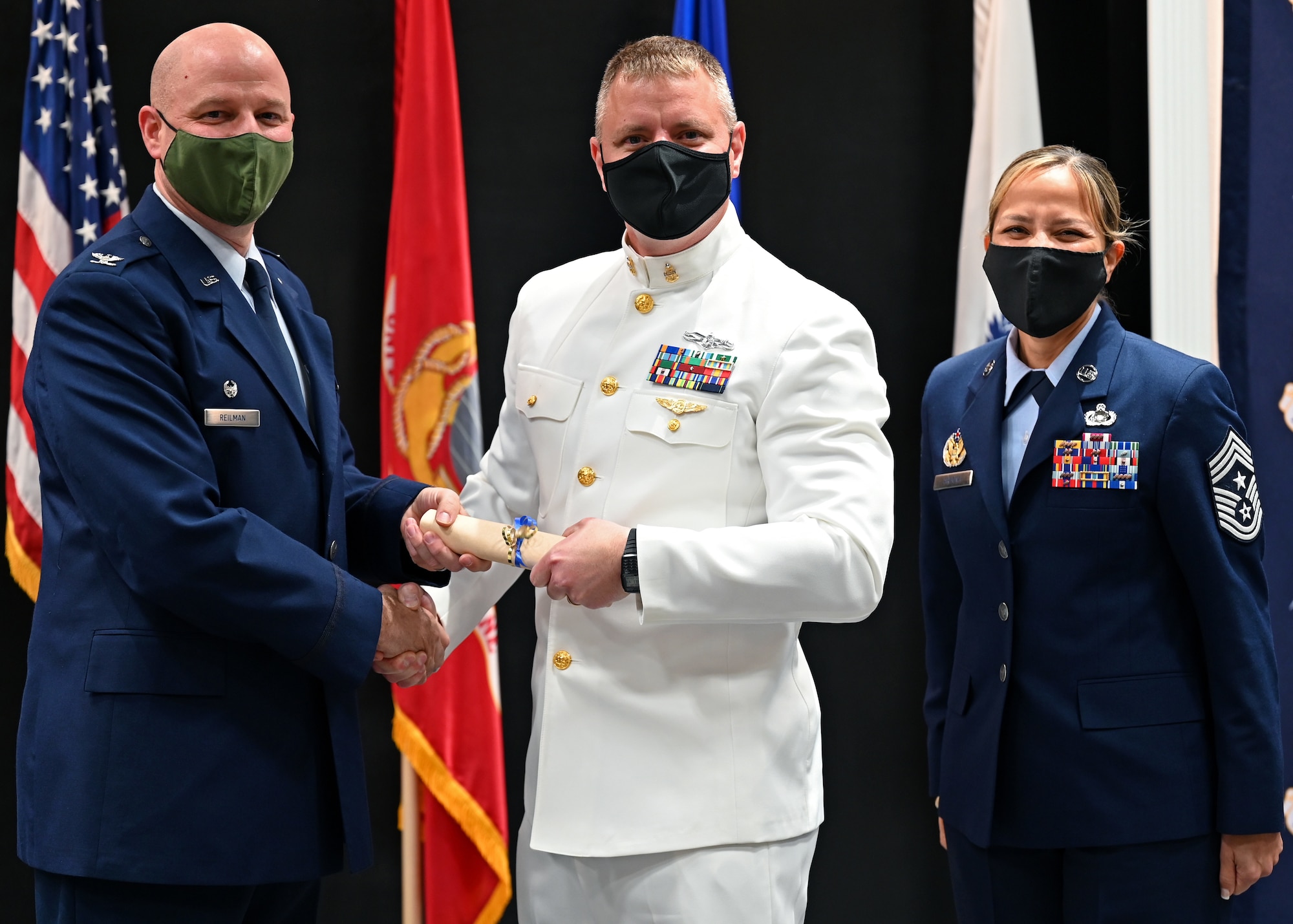 U.S. Air Force Col. Matthew Reilman, 17th Training Wing commander, presents U.S. Navy Senior Chief Petty Officer Jason Sikora, Naval Detachment Goodfellow, with a diploma from the Community College of the Air Force at the CCAF graduation in the Powell Event Center, Nov. 10, 2021. As an instructor, Sikora was eligible to earn his degree through the CCAF. (U.S. Air Force photo by Senior Airman Ethan Sherwood)