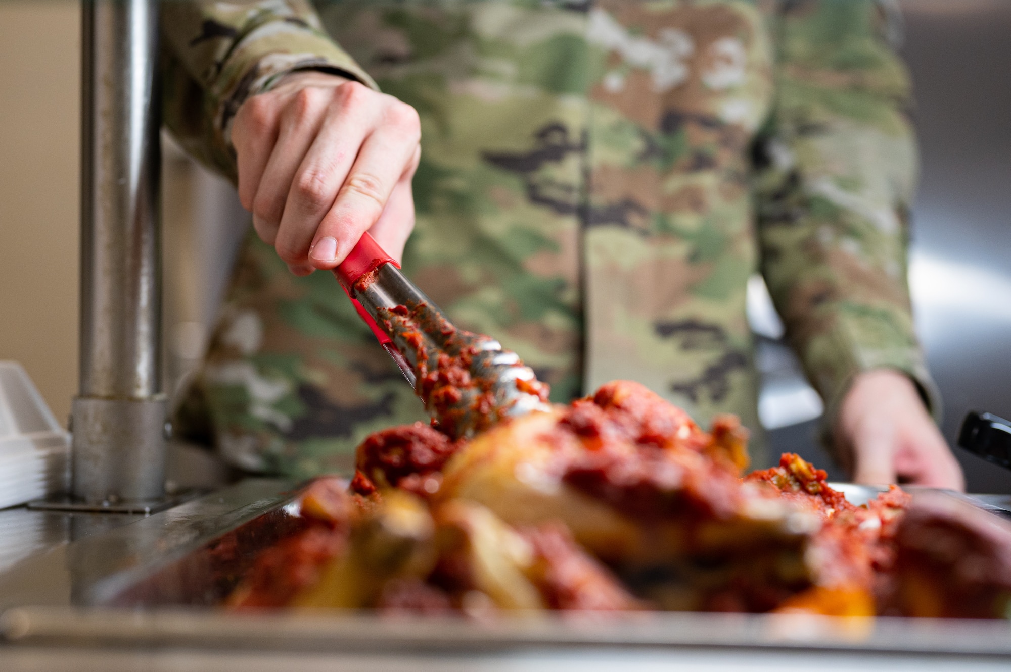 Airman serves chicken.