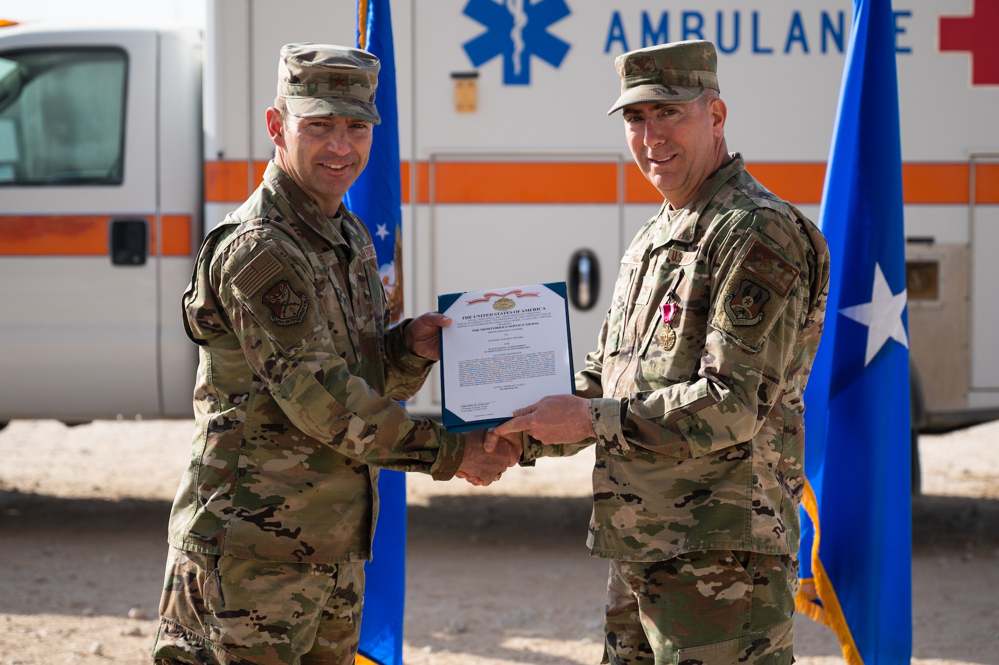 Col. Wayne Peters, right, outgoing 378th Expeditionary Medical Group commander, receives the Meritorious Service Medal from Brig. Gen. Robert Davis, left, 378th Air Expeditionary Wing commander, during the 378th EMDG change of command ceremony at Prince Sultan Air Base, Kingdom of Saudi Arabia, Nov. 9, 2021. The Meritorious Service Medal is awarded to members of the armed services who distinguish themselves by outstanding service to the United States. (U.S. Air Force photo by Senior Airman Jacob B. Wrightsman)