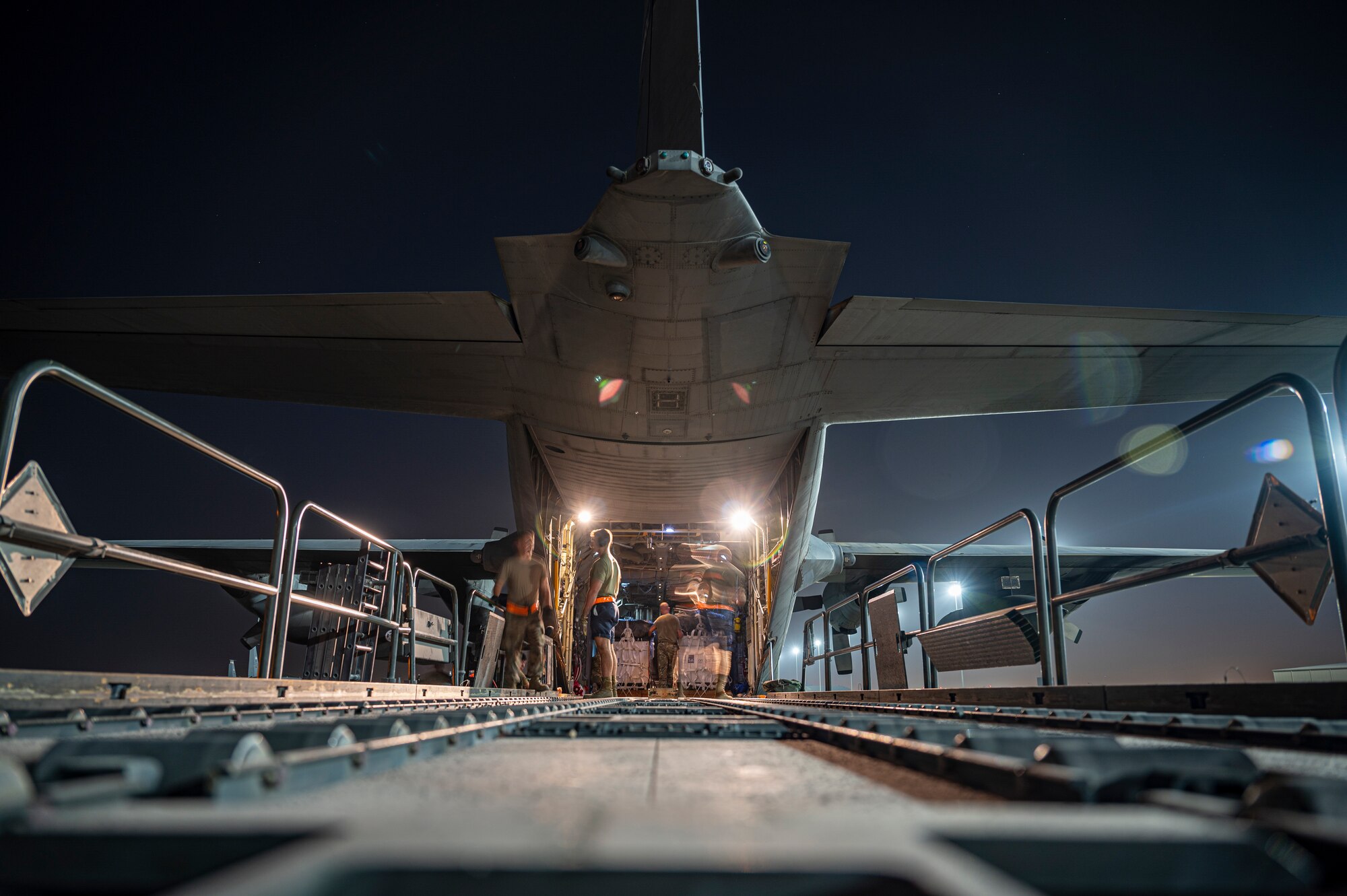 Members assigned to the 779th Expeditionary Airlift Squadron and 8th Expeditionary Air Mobility Squadron load cargo to be air-dropped  into a C-130H Hercules at Al Udeid Air Base, Qatar, Oct. 31, 2021.
