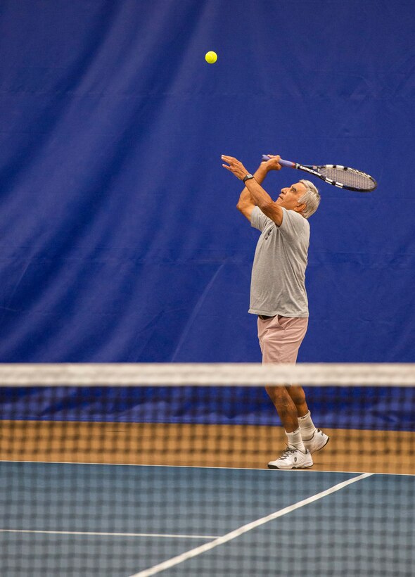 Sunder Bhatla, serves up a tennis ball while playing tennis inside the base Tennis Club, Nov 1, 2021, at Wright-Patterson Air Force Base, Ohio. The club offers 4 LED lit courts to play on and several other amenities for those who need to practice. (U.S. Air Force photo by Wesley Farnsworth)