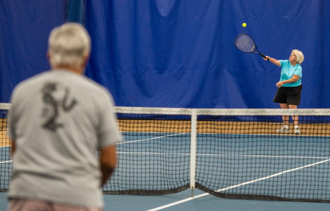 Chris Sitko serves a tennis ball to Sunder Bhatla, during a match inside the base Tennis Club, Nov 1, 2021, at Wright-Patterson Air Force Base, Ohio. The club offers 4 LED lit courts to play on and several other amenities for those who need to practice. (U.S. Air Force photo by Wesley Farnsworth)