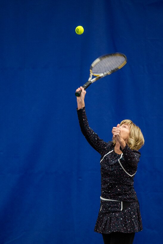 Kathi Malina, serves up a tennis ball while playing tennis inside the base Tennis Club, Nov 1, 2021, at Wright-Patterson Air Force Base, Ohio. The club offers 4 LED lit courts to play on and several other amenities for those who need to practice. (U.S. Air Force photo by Wesley Farnsworth)