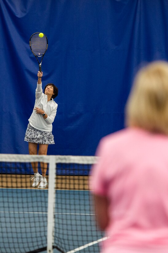 Annette Oakes, serves up a tennis ball while playing tennis inside the base Tennis Club, Nov 1, 2021, at Wright-Patterson Air Force Base, Ohio. The club offers 4 LED lit courts to play on and several other amenities for those who need to practice. (U.S. Air Force photo by Wesley Farnsworth)