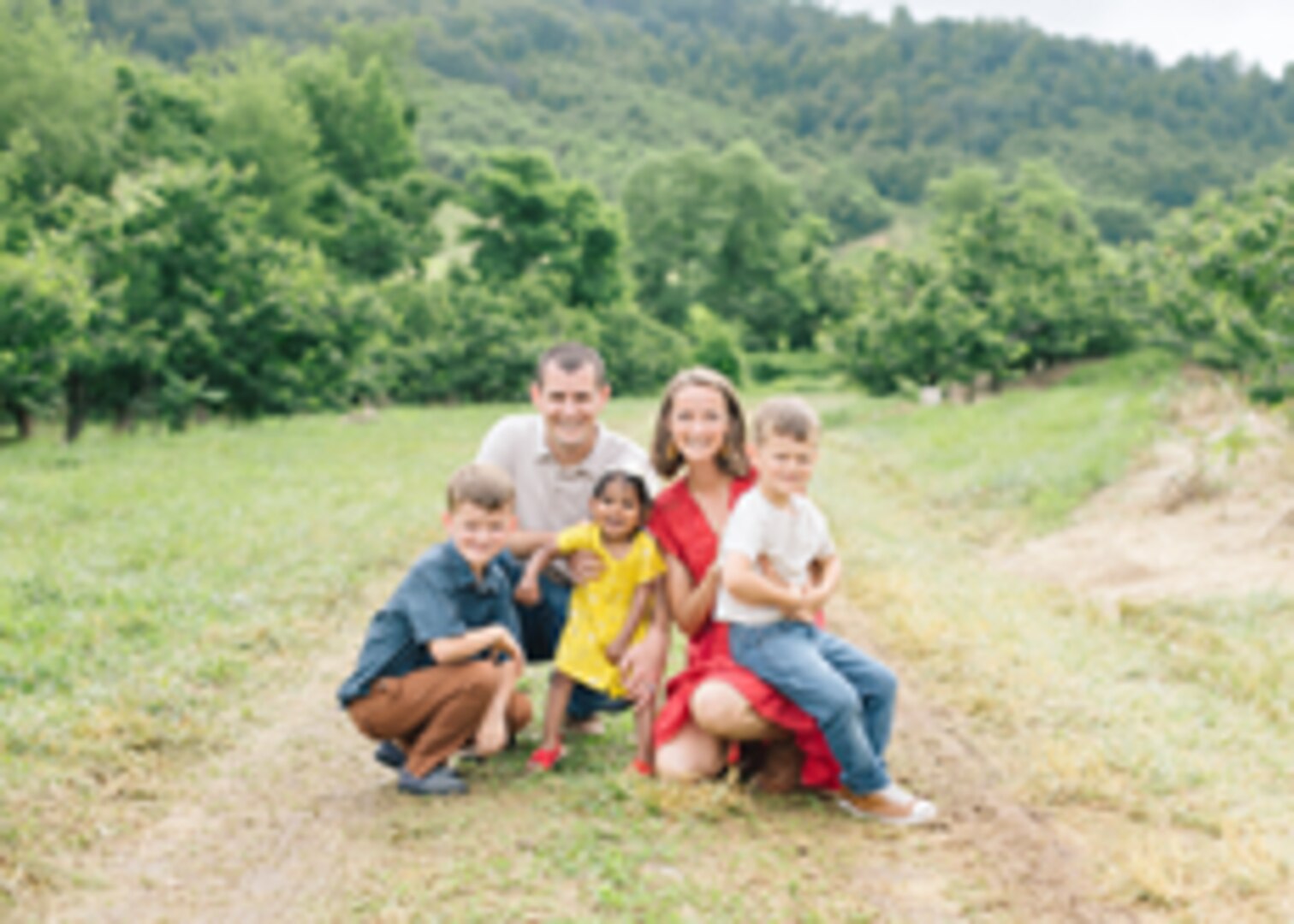 Lt. Cmdr. Kirk Kalmbacher (top left), his wife Caroline (top right) and their children pose for a family picture.