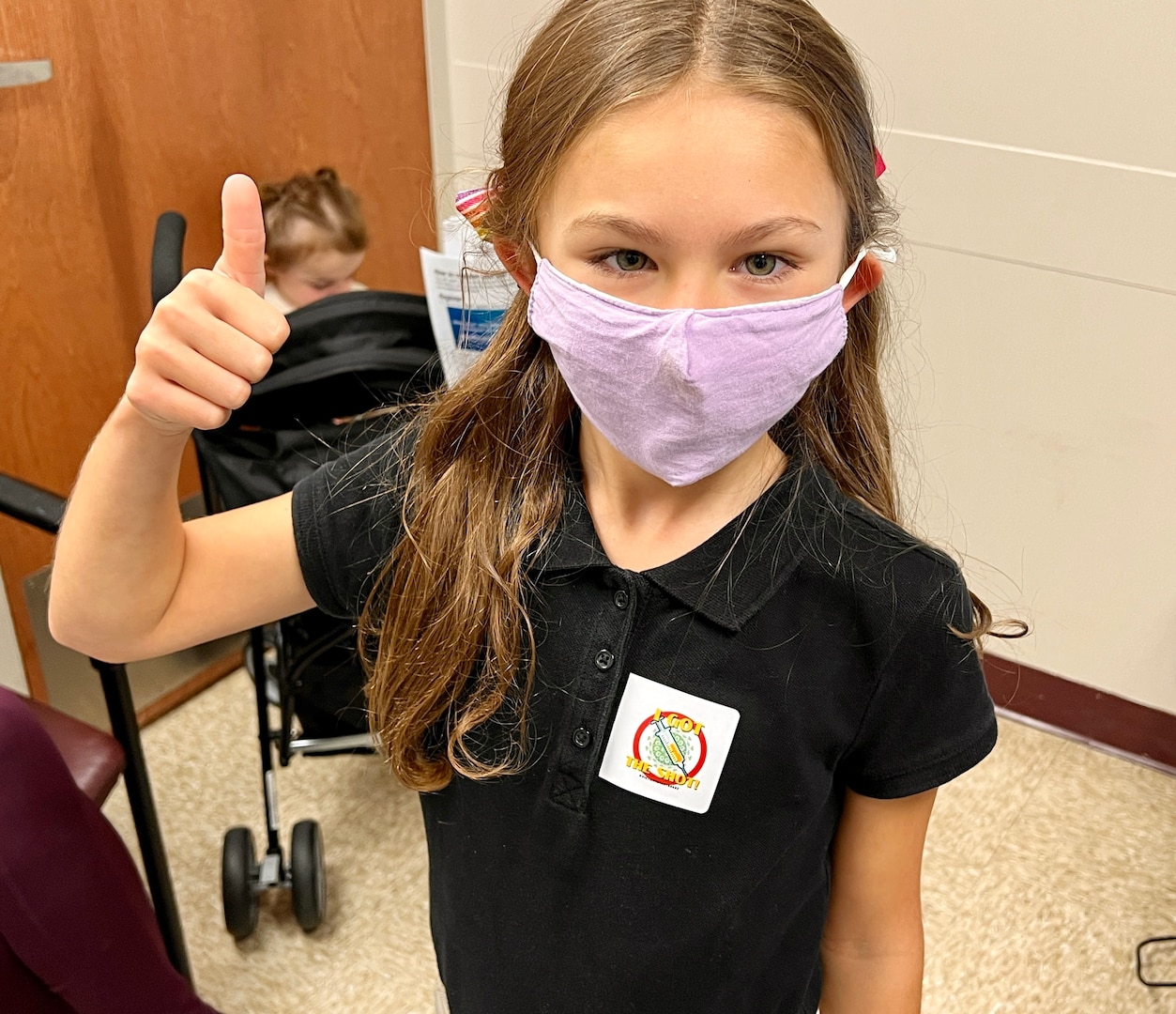 Sianna Gautier (8), daughter of Command Sgt. Maj. Joshua Dumond, gives the thumbs up after receiving her first dose of the the Pfizer-BioNTech pediatric COVID-19 vaccine