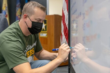 Scott Ferge, U.S. Army Financial Management Command systems accountant, marks another task complete on a whiteboard during the U.S. Army’s year-end close at the Maj. Gen. Emmett J. Bean Federal Center in Indianapolis Oct. 1, 2021. Year-end close encompasses all Army components and echelons from Army commands in coordination with Headquarters Department of the Army, USAFMCOM and the Defense Finance and Accounting Service and other federal entities. (U.S. Army photo by Mark R. W. Orders-Woempner)