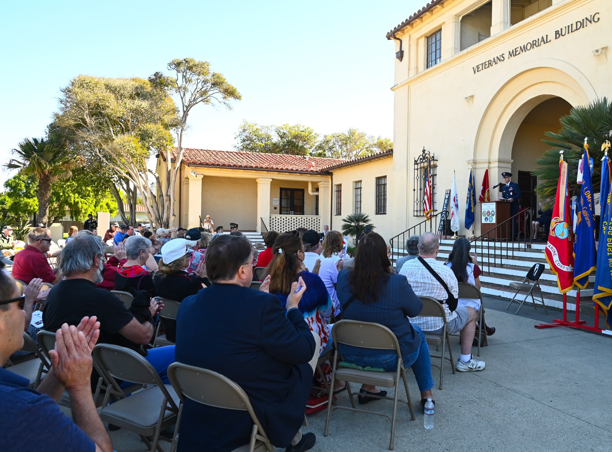 People sitting outside listing to speech