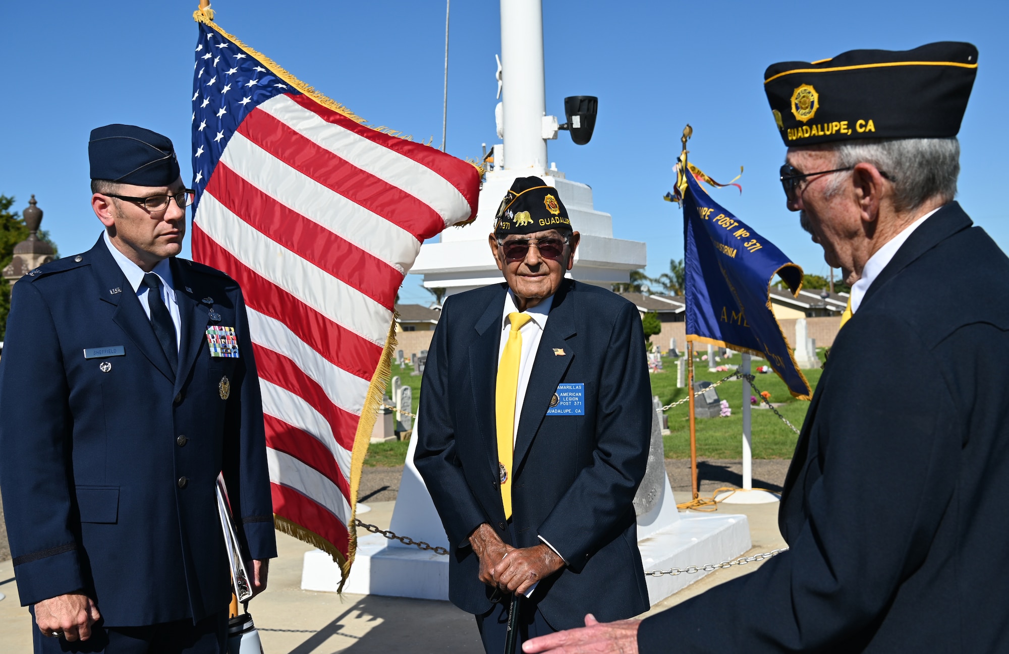 Three men standing and speaking to each other