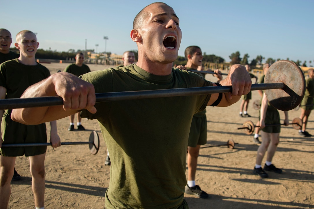 A Marine Corps shouts while lifting a weighted bar.