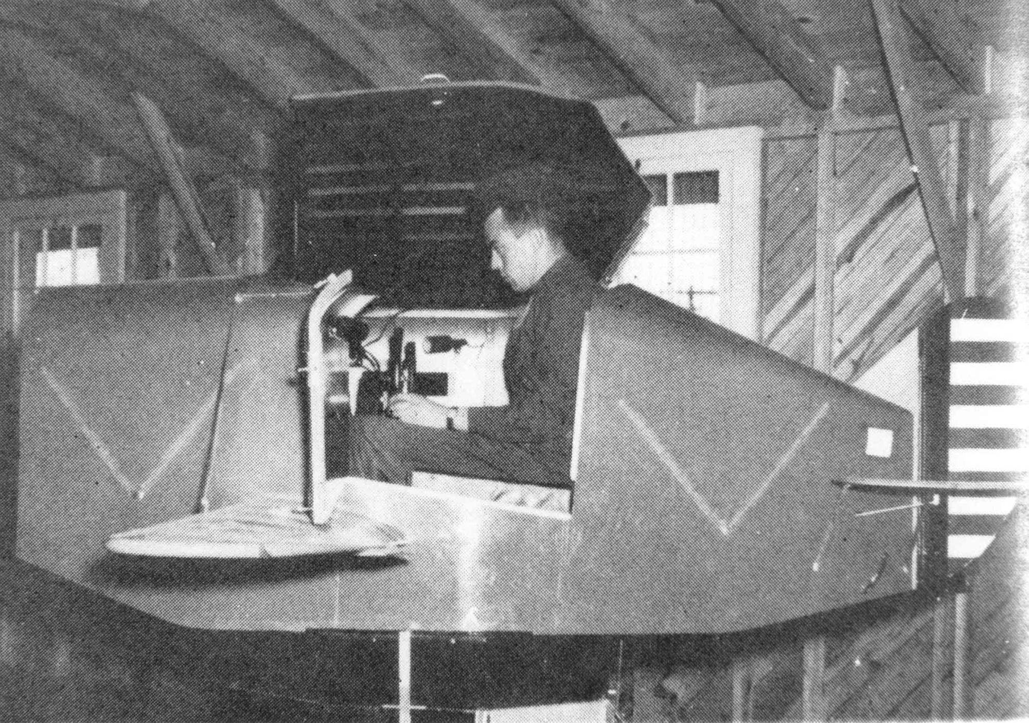 A student pilot in the WWII era trains in a Link Trainer.