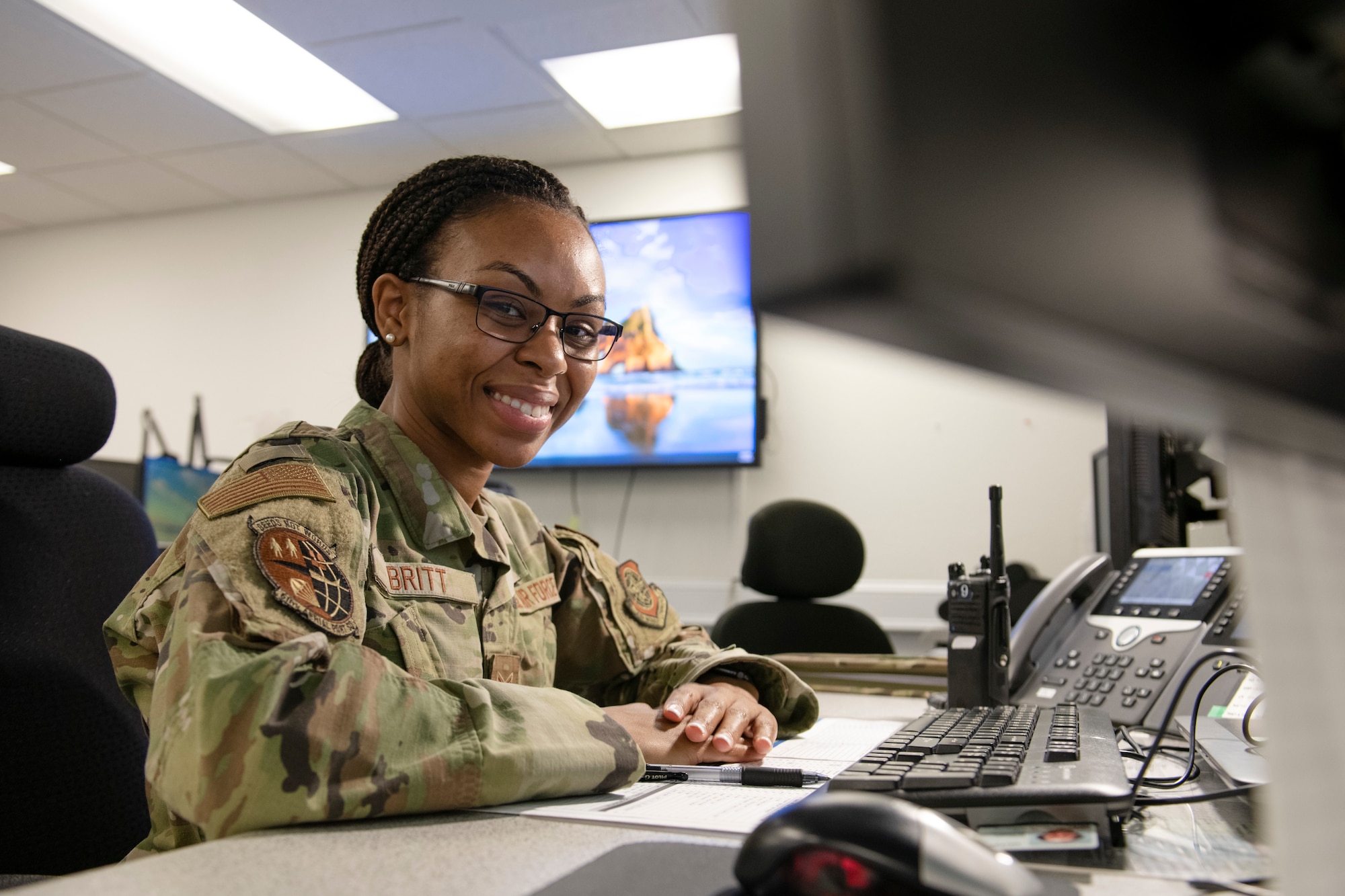 Senior Airman Aundrea Britt, 60th Aerial Port Squadron Air Transportation Operation Center information controller, sits at her at work station desk in front of two monitors Nov. 3, 2021, at Travis Air Force Base, California.