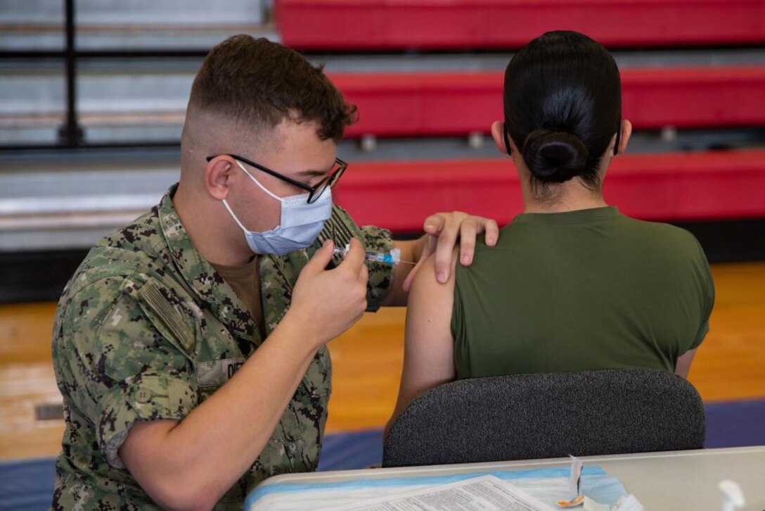 U.S. Navy Hospitalman Elias Dietz, with the Naval Health Clinic Quantico, administers the flu vaccine to a Marine on Marine Corps Base Quantico, Virginia, Oct. 25, 2021. The flu vaccine is administered annually to maintain the health and mission readiness of the force.