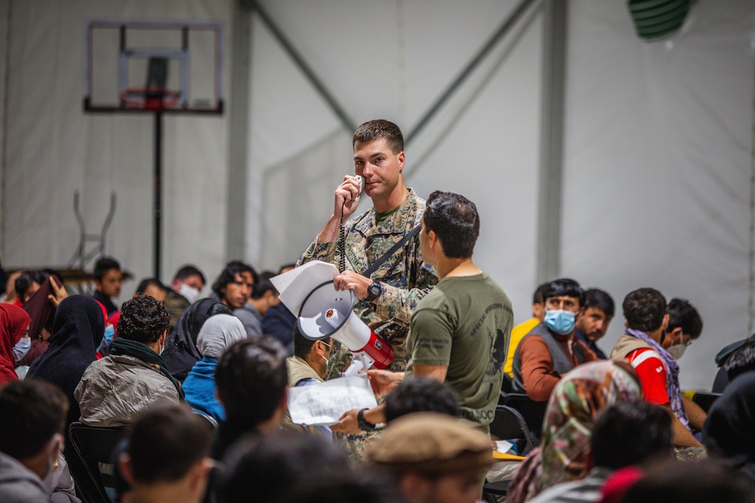 U.S. Marine Corps Capt. Nicholas Kostovny, a company commander with 2d Assault Amphibian Battalion, currently assigned to Task Force Pickett, gives a welcome aboard brief to new Afghan evacuees aboard Fort Pickett, Virginia, Oct. 9, 2021.