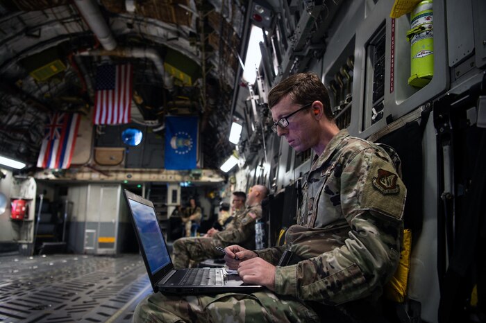 Tech. Sgt. Carl Williams, 747th Cyberspace Squadron standards and evaluations craftsman, observes radio frequencies recorded by a stand-alone hub activity reconnaissance kit while aboard a C-17 Globemaster III near the Hawaiian Islands, Nov. 3, 2021. A Mission Defense Team from the 747th CS and Airmen from the 535th Airlift Squadron worked together to defend the C-17 from cyber attacks by preventing adversaries from invading the airspace and manipulating aircraft data.