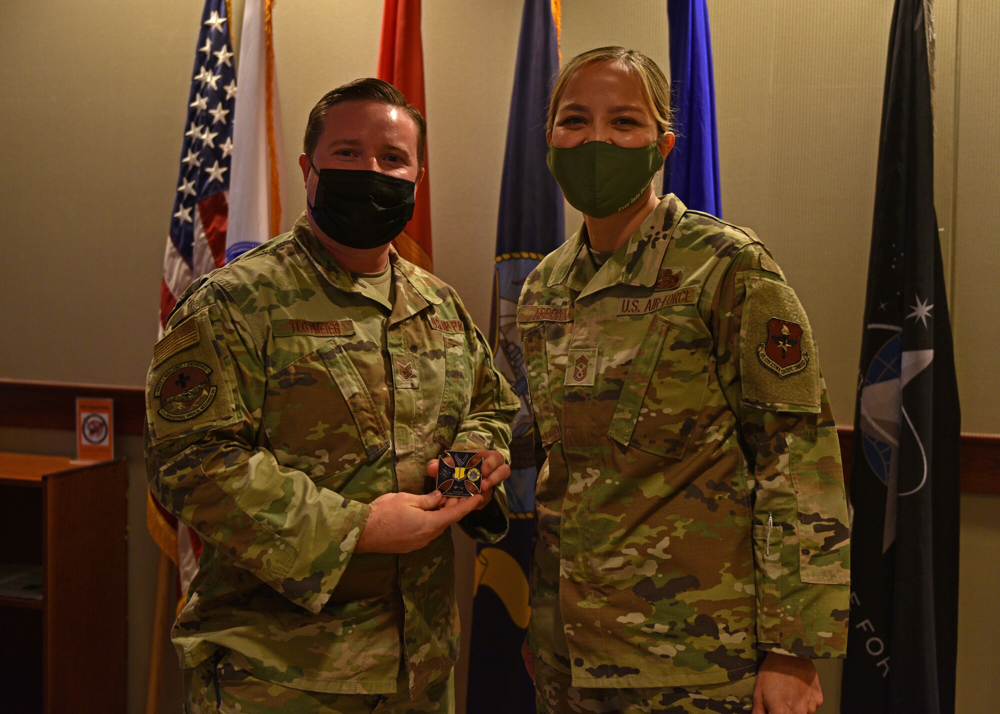 U.S. Air Force Tech. Sgt. Ryan Tegtmeier, 17th Operational Medical Readiness Squadron Military Medicine Clinic flight chief, and Chief Master Sgt. Rebecca Arbona, 17th Training Wing command chief, pose for a photo on Goodfellow Air Force Base, Texas, Nov. 9. Tegtmeier was coined for his role in ensuring all uniformed personnel receive proper care at the Ross Clinic. (U.S. Air Force photo by Senior Airman Ashley Thrash)