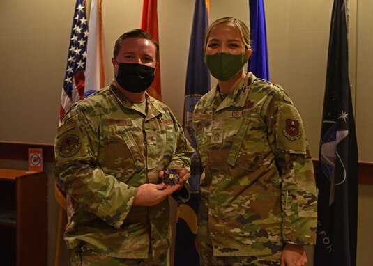U.S. Air Force Tech. Sgt. Ryan Tegtmeier, 17th Operational Medical Readiness Squadron Military Medicine Clinic flight chief, and Chief Master Sgt. Rebecca Arbona, 17th Training Wing command chief, pose for a photo on Goodfellow Air Force Base, Texas, Nov. 9. Tegtmeier was coined for his role in ensuring all uniformed personnel receive proper care at the Ross Clinic. (U.S. Air Force photo by Senior Airman Ashley Thrash)