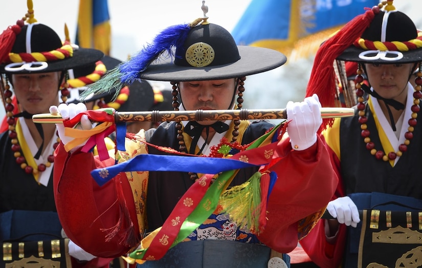 A photo shows ceremony participants in colorful dress.