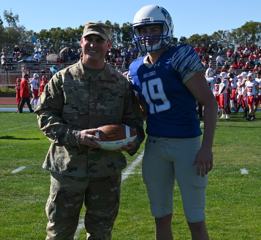 Colton Theaker, a kicker for the Allan Hancock College Bulldogs and Chief Master Sgt. Jason DeLucy, Space Launch Delta 30 command chief, pose for a photo Nov. 13, 2021, Santa Maria, Calif. Theaker presented a gift for Vandenberg Space Force Base to DeLucy. (U.S. Space Force photo by Airman First Class Tiarra Sibley)