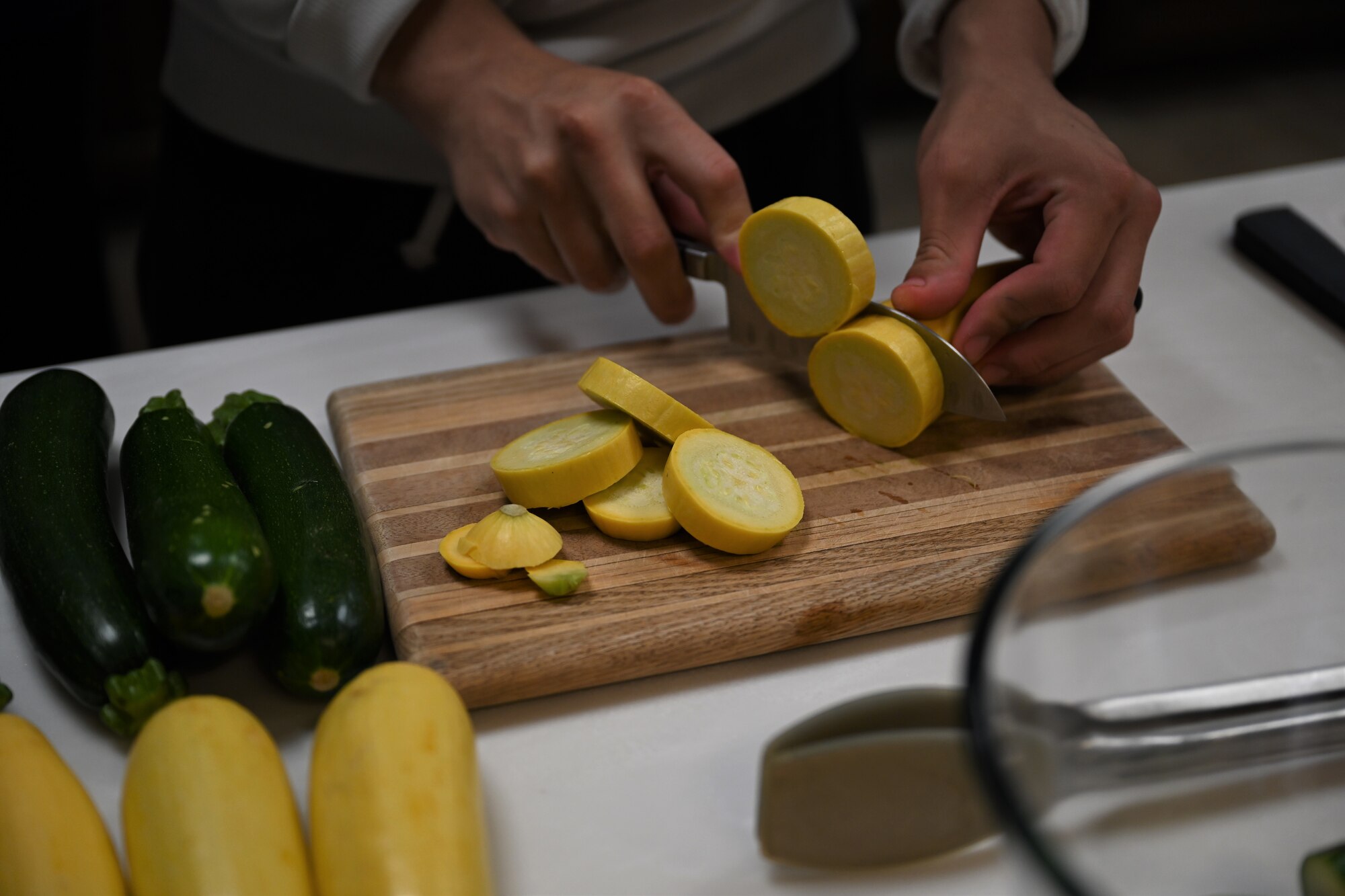 An Airman chops squash to make kabobs, during a cooking class, Nov. 5, 2021, at Montgomery Village on Columbus Air Force Base. The village located at the Unaccompanied Enlisted Dorms houses a fully furnished kitchen, accessible to any dorm resident that would like to use it. (U.S. Air Force photo by Airman 1st Class Jessica Haynie)