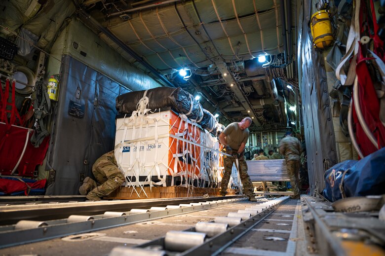 Loadmasters assigned to the 779th Expeditionary Airlift Squadron load cargo to be air-dropped into a C-130H Hercules at Al Udeid Air Base, Qatar, Oct. 31, 2021.