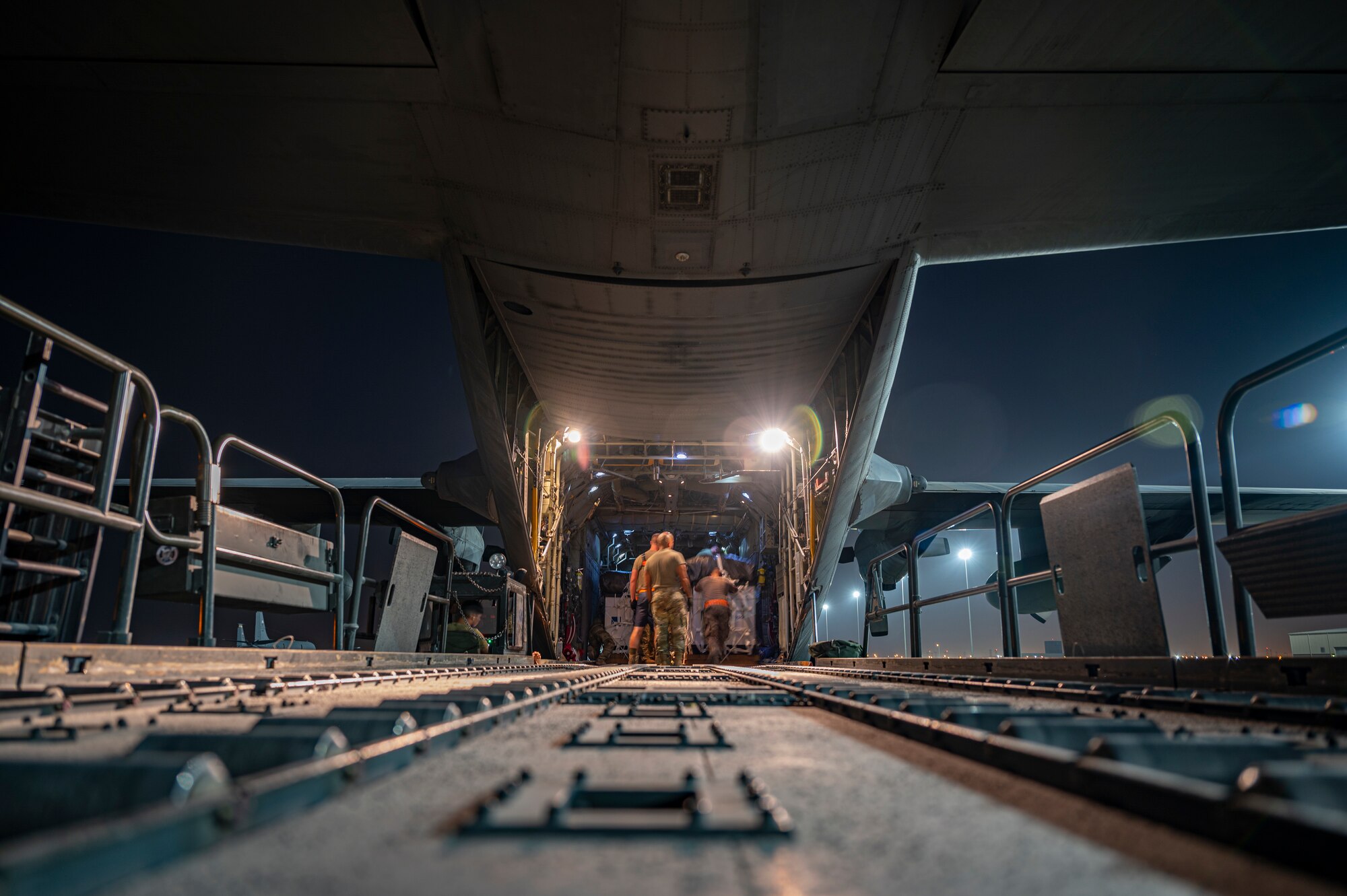 Members assigned to the 779th Expeditionary Airlift Squadron and 8th Expeditionary Air Mobility Squadron load cargo to be air-dropped into a C-130H Hercules at Al Udeid Air Base, Qatar, Oct. 31, 2021