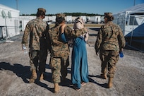 U.S. Marines assigned to the Female Engagement Team with 3rd Battalion, 6th Marine Regiment, walk with an Afghan individual on Fort Pickett, Virginia, Sept. 24, 2021.